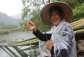 “钓鱼婆婆”垂钓于水库滩边,锻炼身体修身养性